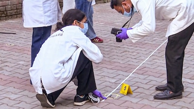 National Investigation Agency inspect the site after a blast outside the Punjab BJP headquarters, in Chandigarh on April 1. (PTI photo)