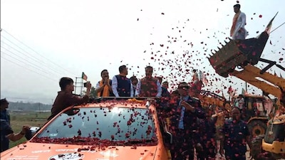 As the convoy arrived, the excavator’s mechanical arm lifted and released a cascade of flower petals over the crowd.