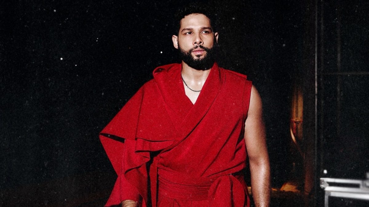 Siddhant Chaturvedi in a bright red Assassin’s Creed‑styled outfit performing on stage