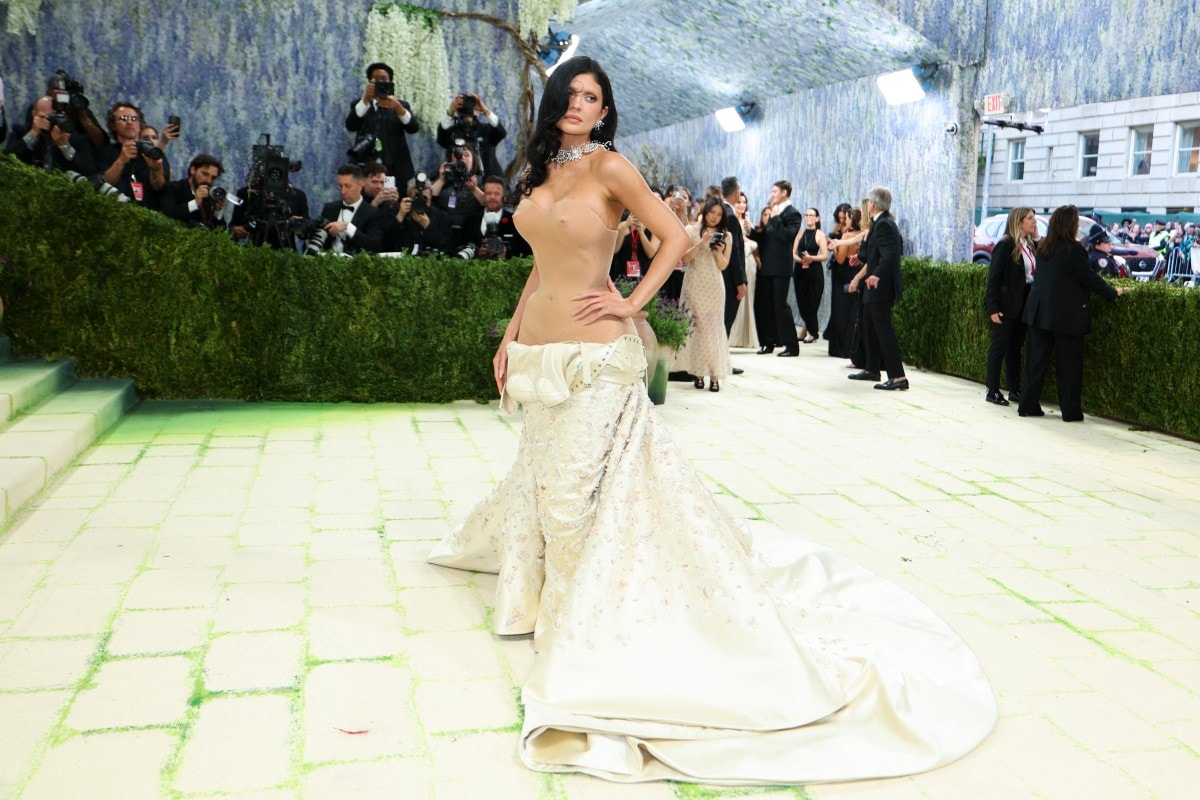 Kylie's 11,000 hours "Undone" Masterpiece In her ninth appearance, Kylie Jenner stunned with a custom Schiaparelli creation that looked like it was falling apart in real time. The look featured a nude-toned molded corset bodice, complete with faux anatomical details, paired with a voluminous butter-colored duchess satin skirt. The craftsmanship was astonishing: more than 11,000 hours were spent on the embroidery, which included natural baroque pearls and thousands of satin stitch elements. She based the edgy look with bleached brows and a unique, sculpted "forehead curl."
