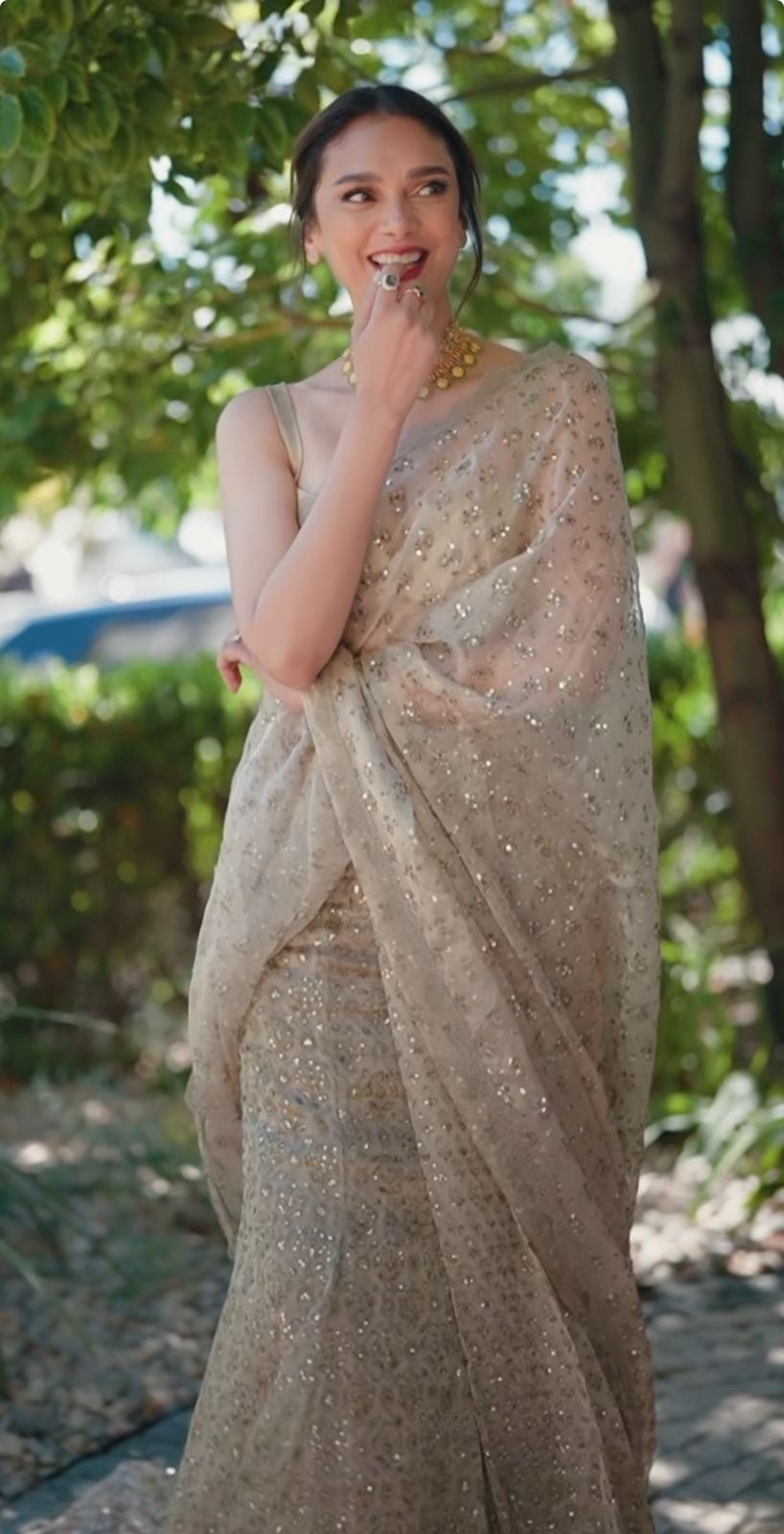 Breaking away from the monochromatic tones of the saree, a rich, berry-red lip acts as the focal colour statement.