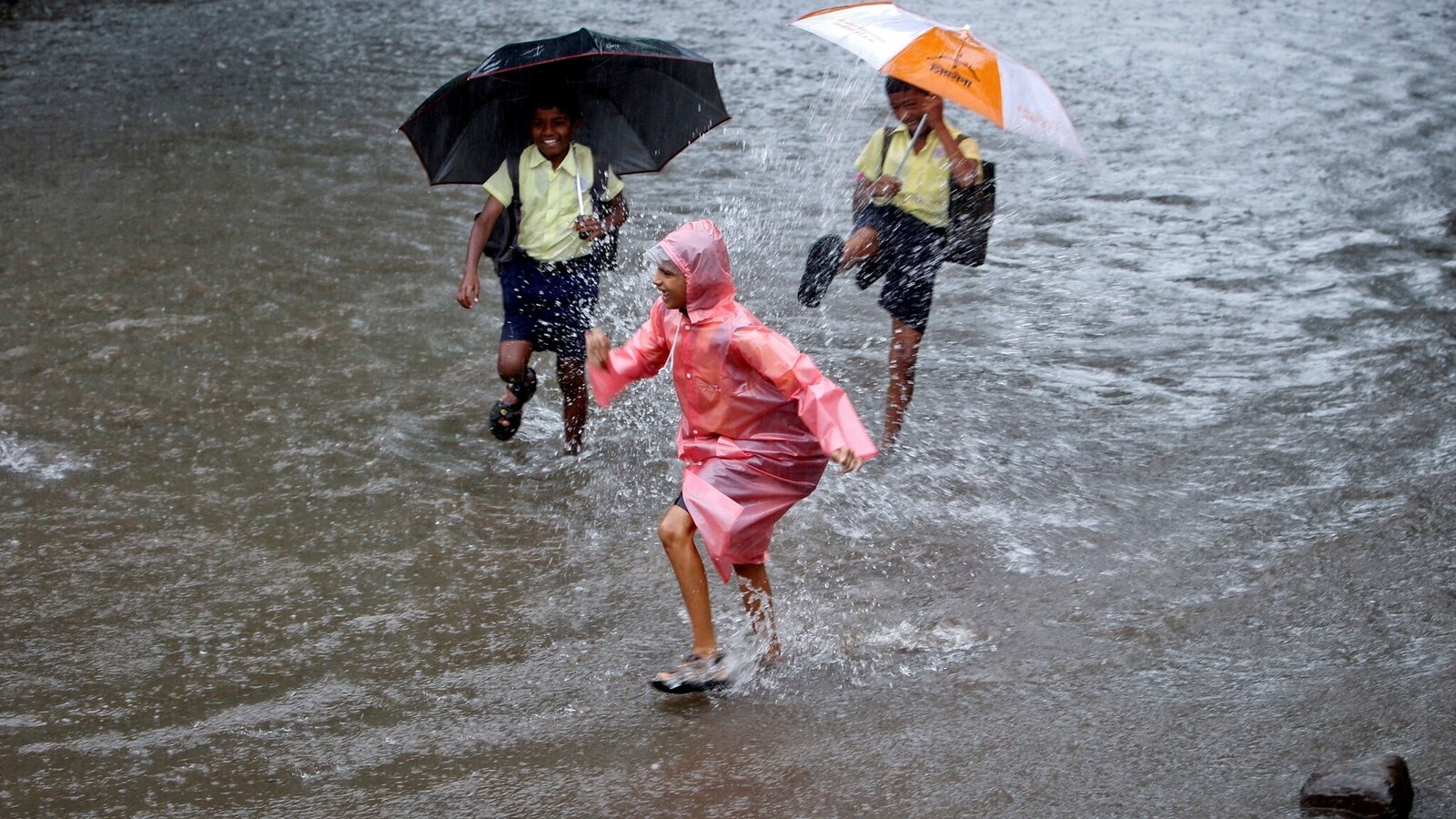 FILE PHOTO: FILE PHOTO: FILE PHOTO: School children play on a flooded street during heavy monsoon rains in Mumbai