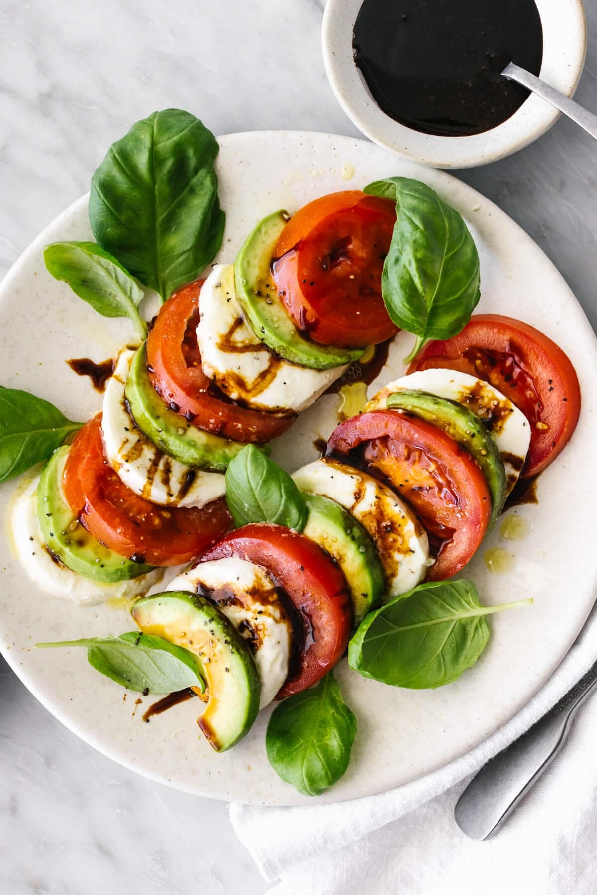 Caprese Avocado Salad: Juicy heirloom tomatoes and hydrating cucumbers are layered with creamy avocado slices and fresh mozzarella pearls. Drizzled with extra virgin olive oil and a rich balsamic reduction, this salad offers deep hydration alongside heart-healthy monounsaturated fats.