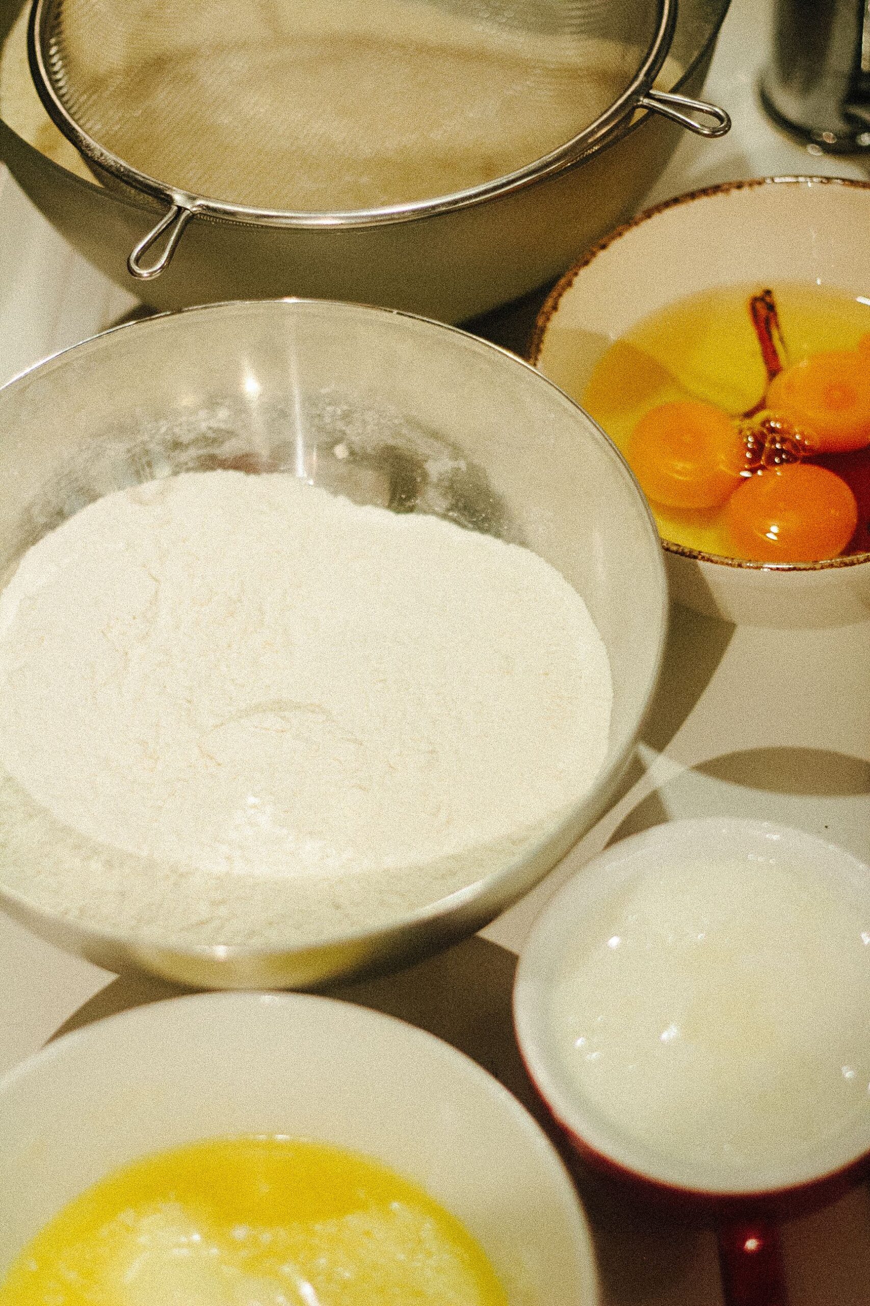 Next, preheat the beaten eggs into the well and beat until smooth. Now, add a little milk to loosen it. 