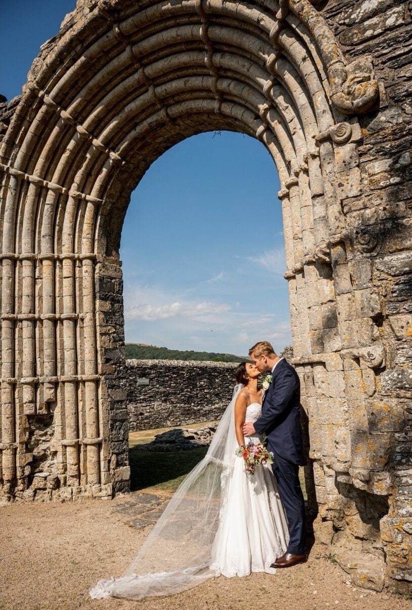Complementing Jennifer's elegant appearance, William Ishmael wore a classic navy-blue three-piece suit paired with a cream waistcoat and matching tie. The timeless outfit perfectly matched the understated elegance of the countryside wedding.