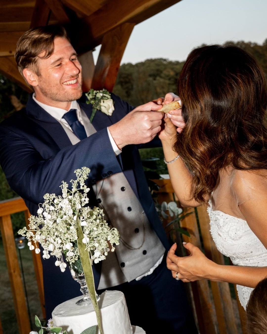 Other images show them cutting their wedding cake, walking hand in hand after the ceremony and posing against the picturesque countryside backdrop.