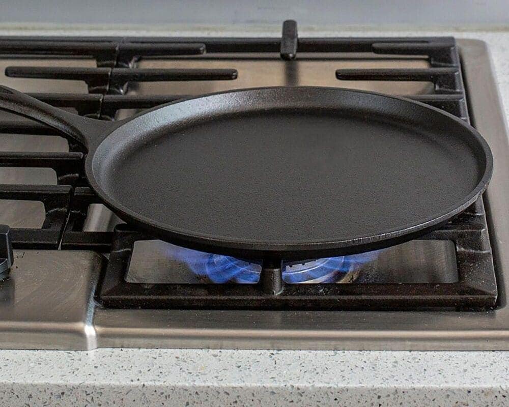 Step 3: Heat a non-stick pan and lightly grease it with oil. Arrange the sliced shallots and zucchini evenly on the pan and let them cook for a minute or two.