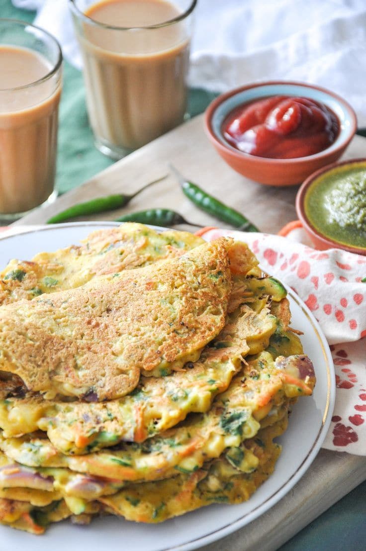 Step 6: Transfer the chilla to a plate, top with freshly grated paneer and a little chopped coriander. Serve hot with coriander-mint chutney or plain yogurt.