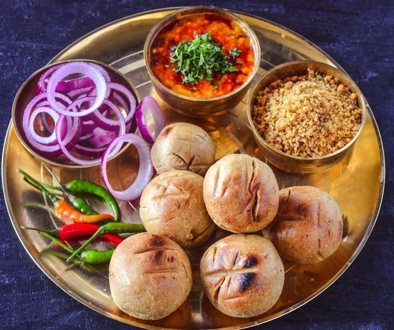 Dal Baati Churma – RajasthanA staple of Rajasthani cuisine, Dal Baati Churma brings together three distinct elements. Baati is baked wheat dough, dal provides the lentil component, while churma is a sweet, crumbly preparation made from wheat and ghee.