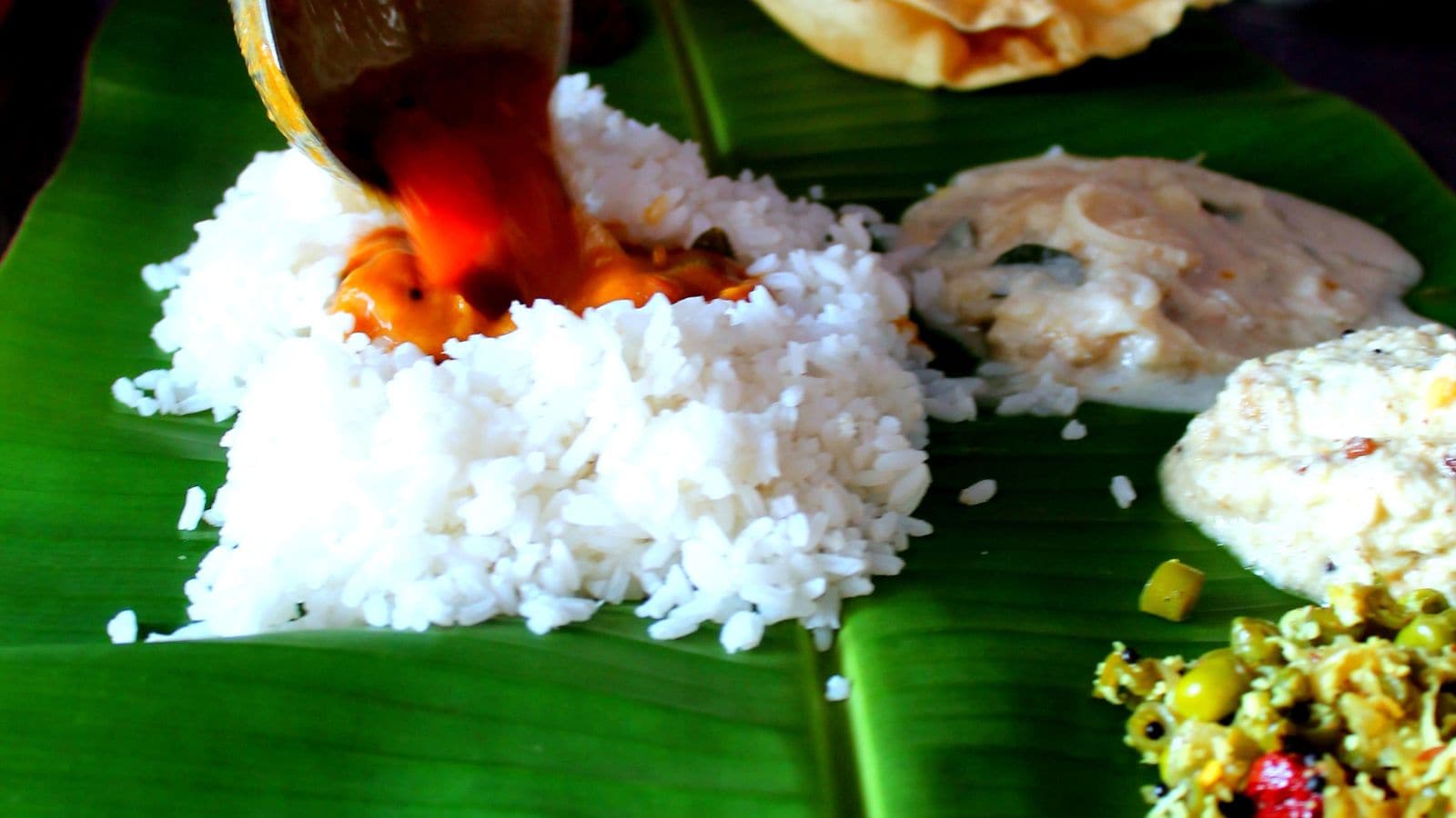 The Must-Have Crunchy SidesNo Sadya is complete without its collection of accompaniments. Crisp banana chips and pappadam provide crunch, while sharkara upperi, or jaggery-coated banana chips, brings sweetness to the spread. Pickles and inji puli, a punchy preparation made with ginger and tamarind, add sharp, tangy flavours. These smaller portions may occupy less space on the banana leaf, but they play an important role in balancing the meal.