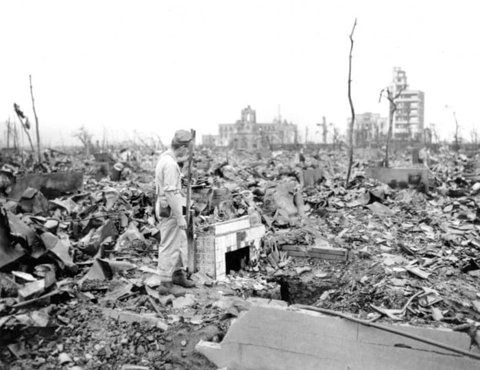 A survivor stands beside the remains of a destroyed home in Hiroshima in September 1945, weeks after the atomic bomb attack devastated the city. (Image: AP file)