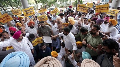 AAP MLAs and party workers, several wearing turbans in party colours, gather outside the GMADA office in Mohali on September 24, holding yellow placards with Punjabi slogans including "Punjab Rahega Zindabad," during a protest against ED raids ahead of the Punjab Assembly elections. (Image Courtesy: AAP)