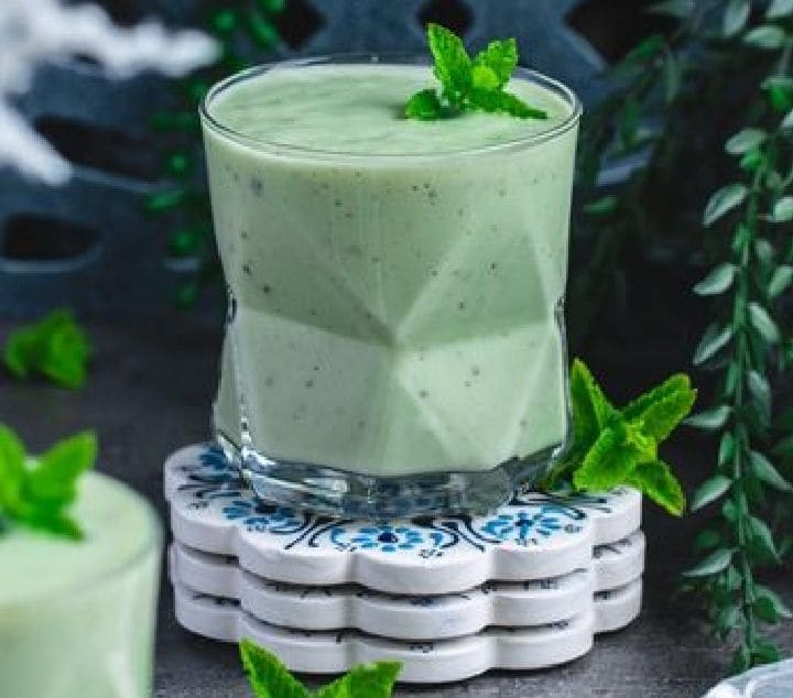 Avocado Mint Lassi: A velvety refreshment blending cultured probiotic yoghurt, chilled avocado pulp, fresh mint leaves, and roasted cumin powder. Richer than standard buttermilk, this soothing green drink cools the digestive system instantly while offering nutrient-dense healthy fats. 