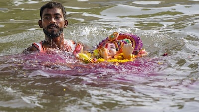 A man immerses an idol of lord Ganesh during the ongoing 'Ganesh Chaturthi' festival, in Ajmer district, Rajasthan. (PTI Photo)