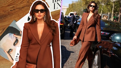 Huma Qureshi channelled Parisian power dressing in a chocolate-brown Gabriela Hearst suit, pairing sharp tailoring with a plunging neckline, sculptural gold earrings and bold shades.