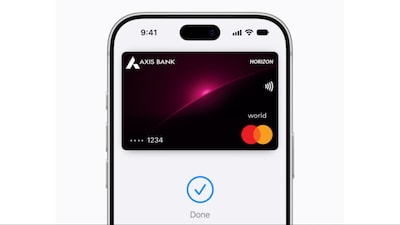 iPhone held to a payment terminal to pay with Apple Pay in a store.