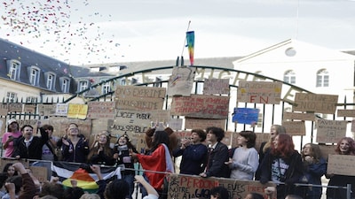 Protesters stand behind the gates of the Michelet high school, covered with placards, as confetti is thrown during a demonstration of high-school students as part of a nationwide protest movement over learning conditions in Vanves, outside Paris, on October 6, 2026.