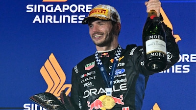 Winner Red Bull Racing's Dutch driver Max Verstappen celebrates with his trophy on the podium after the Formula One Singapore Grand Prix at the Marina Bay Street Circuit in Singapore on October 11, 2026. (Photo by ROSLAN RAHMAN / AFP)
