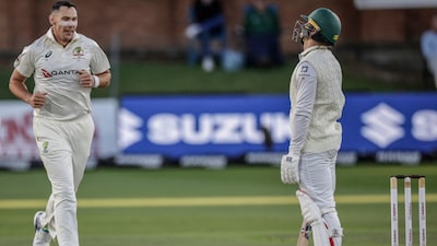 Australia's Scott Boland (L) celebrates after taking the wicket of South Africa's Ryan Rickelton (R) on day two of the second Test match between South Africa and Australia at St Georges Park in Gqeberha on October 19, 2026. (Photo by Marco Longari / AFP)