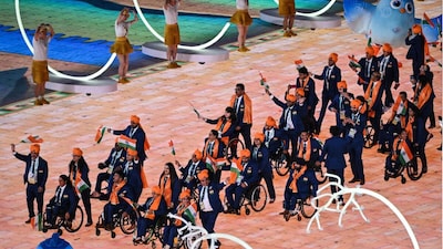 India's delegation wave their country's national flag as they take part in the athletes parade during the opening ceremony of the 2022 Asian Para Games at the Hangzhou Olympic Sports Centre Stadium (Picture credit: AFP)