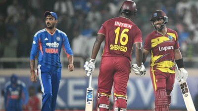 Shai Hope shakes hands with teammate Romario Shepherd after winning the second T20I as Axar Patel looks on (Picture credit: AFP)