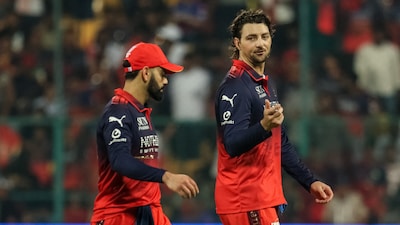 Royal Challengers Bengaluru's Australian cricket player Tim David (R) speaks with teammate Indian cricket player Virat Kohli during the 2026 Indian Premier League (IPL) T20 match between Royal Challengers Bengaluru and Chennai Super Kings at the M Chinnaswamy Stadium in Bengaluru on April 5, 2026. (Photo by AFP)