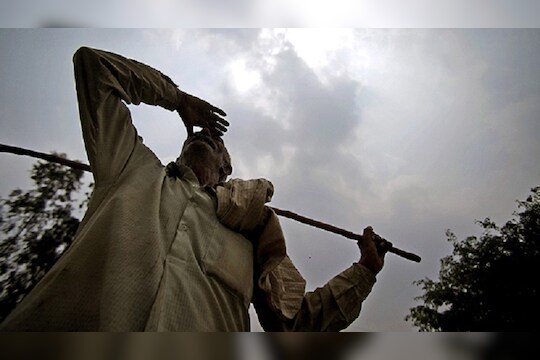 An Indian farmer looks at an overcast sky on the outskirts of Jammu, India, Tuesday, July 24, 2012. Indians have grown increasingly desperate waiting for the long-delayed monsoon, the annual rains that replenish rivers and quench crops to keep this agricultural nation of 1.2 billion fed through the year. So far the rains have fallen at least 22 percent below the national average. (AP Photo/Channi Anand)