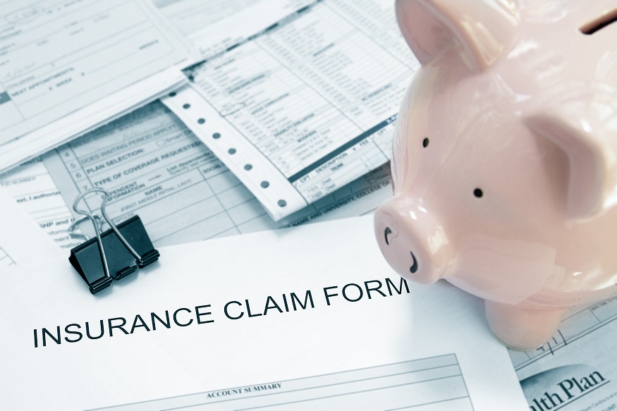 Patient medical bills and insurance claim form, with piggy bank