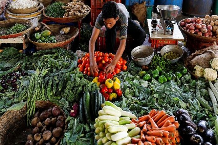 मास्क आणि ग्लोव्हज घातलेल्या भाजी विक्रेत्याकडून भाजी खरेदी करा.