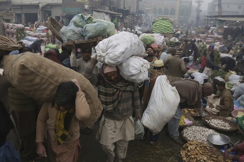 Pakistani laborers work in a fruit and vegetable market during the first morning of the New Year in Lahore, Pakistan, Tuesday, Jan. 1, 2019. (AP Photo/K.M. Chaudary)