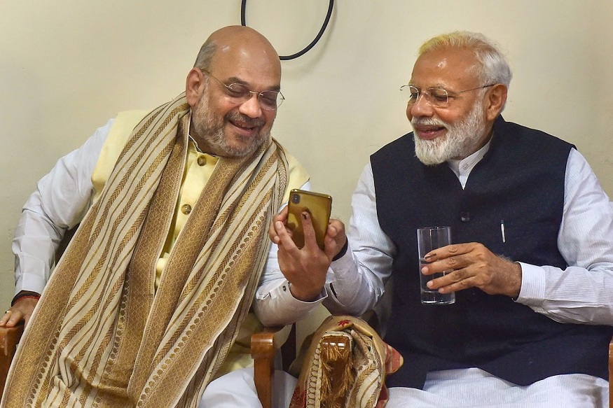 Varanasi: Prime Minister Narendra Modi and BJP National President Amit Shah look at a mobile phone as they share a light moment before PM's nomination filing ahead of the 2019 general elections, at collector's office in Varanasi, Friday, April 26, 2019. (PTI Photo/Manvender Vashist)(PTI4_26_2019_000085B)
