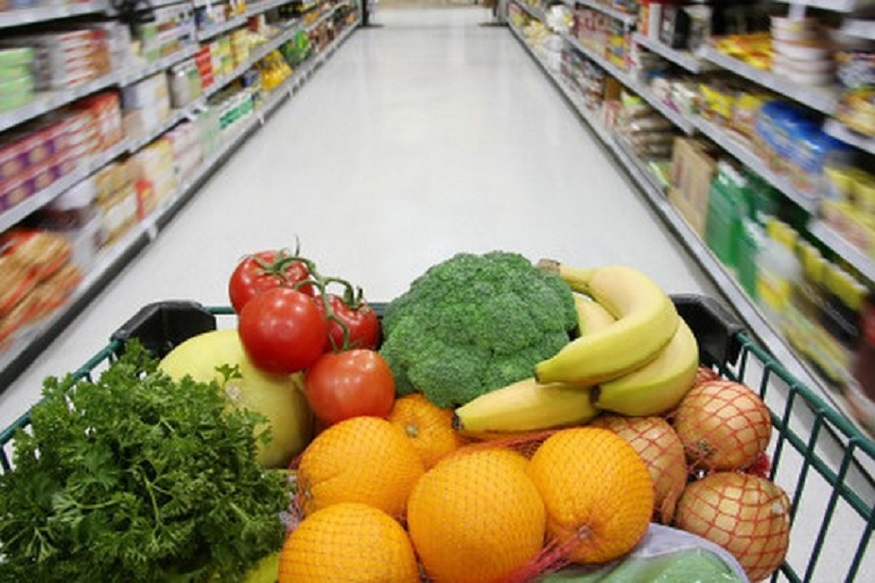 Grocery cart filled with nutritious fruits and vegetables.