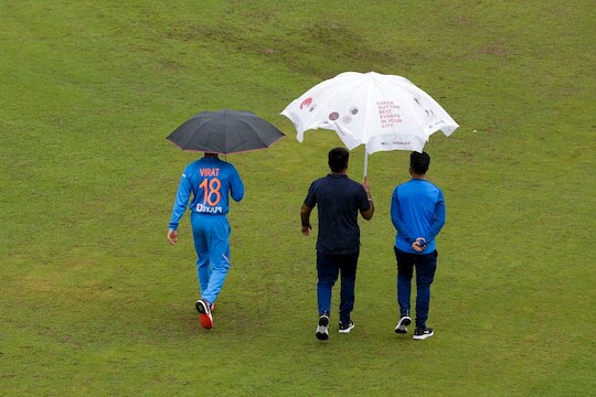 Indian captain Virat Kohli walks under an umbrella as he leaves after addressing a press conference in Dharmsala, India, Saturday, Sept. 14, 2019. India and South Africa will play the first Twenty20 cricket match of the three-match series on Sunday. (AP Photo/Ashwini Bhatia)
