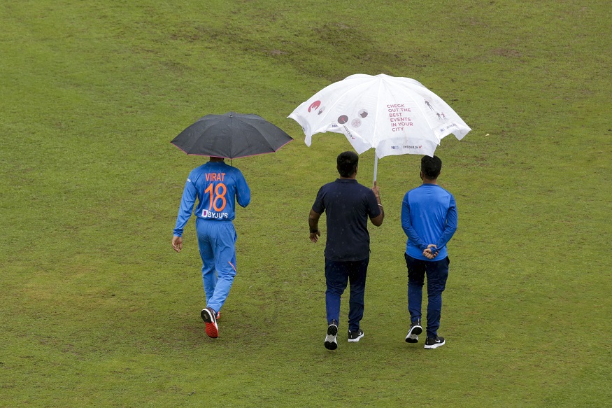 Indian captain Virat Kohli walks under an umbrella as he leaves after addressing a press conference in Dharmsala, India, Saturday, Sept. 14, 2019. India and South Africa will play the first Twenty20 cricket match of the three-match series on Sunday. (AP Photo/Ashwini Bhatia)