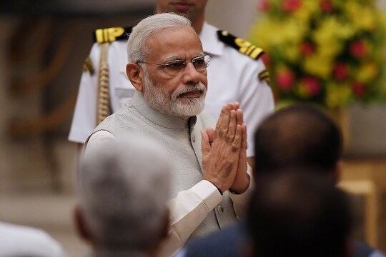Indian Prime Minister Narendra Modi greets attendees during the swearing-in ceremony of new ministers at the Presidential Palace in New Delhi, India, Sunday, Sept.3, 2017. Modi on Sunday reshuffled some of his key minister's portfolios to refurbish his government's image, which has been dented by falling economic indicators. (Prakash Singh/Pool Photo via AP)