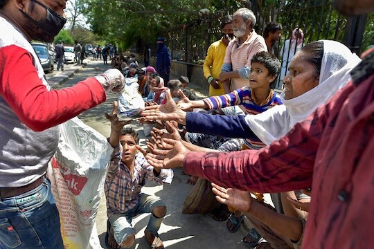 New Delhi: A volunteer distributes food among homeless people near Nizamuddin Mosque during a nationwide lockdown in the wake of coronavirus pandemic, in New Delhi, Tuesday, March 31, 2020.  (PTI Photo/Vijay Verma)(PTI31-03-2020_000073B)