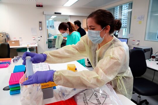 Staff members work as media visit the Microbiology Laboratory of the University Hospital, CHUV, during the coronavirus disease (COVID-19) outbreak in Lausanne, Switzerland, Monday, March 23, 2020. The Swiss authorities proclaimed on March 16, a state of emergency in an effort to halt the spread of the coronavirus and Covid-19 disease. The government declared that all entertainment and leisure businesses will shut down. Grocery stores, and hospitals will remain open and new border controls will be put in place.  (Denis Balibouse/Keystone via AP, Pool)