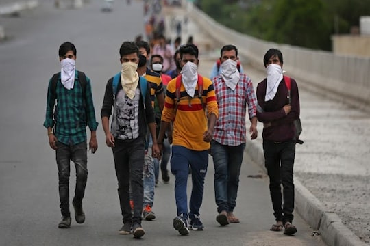 A group of Indian daily wage laborers walk along an expressway hoping to reach their homes, hundreds of kilometers away, as the city comes under lockdown in Ghaziabad, on the outskirts of New Delhi, India, Thursday, March 26, 2020. Some of India's legions of poor and people suddenly thrown out of work by a nationwide stay-at-home order began receiving aid distribution Thursday, as both the public and private sector work to blunt the impact of efforts to curb the coronavirus pandemic. Untold numbers of them are now out of work and many families have been left struggling to eat. (AP Photo/Altaf Qadri)