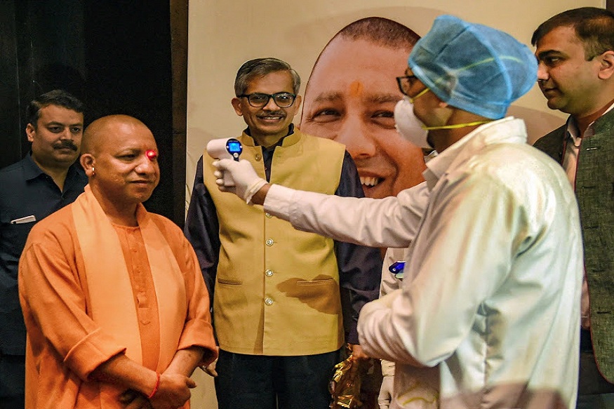 Lucknow: An official uses thermal screening device on Uttar Pradesh Chief Minister Yogi Adityanath, in the wake of deadly coronavirus, prior to his press conference on completion of his three years in office at Lok Bhawan, in Lucknow, Wednesday, March 18, 2020. (PTI Photo/Nand Kumar)(PTI18-03-2020_000083B)