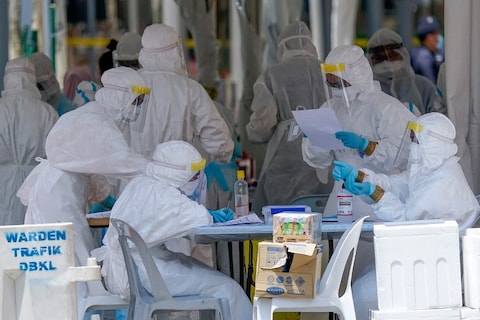 Health workers prepare to screen residents of a building under lockdown during the Movement Control Order in Kuala Lumpur, Malaysia, Thursday, April 9, 2020. The Malaysian government issued a restricted movement order to help curb the spread of the new coronavirus. (AP Photo/Vincent Thian)