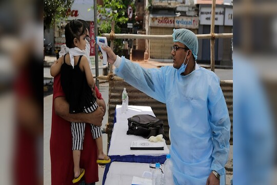 An Indian health worker checks the temperature of a child during lockdown to prevent the spread of new coronavirus in Ahmedabad, India, Wednesday, April 8, 2020. The new coronavirus causes mild or moderate symptoms for most people, but for some, especially older adults and people with existing health problems, it can cause more severe illness or death. (AP Photo/Ajit Solanki)