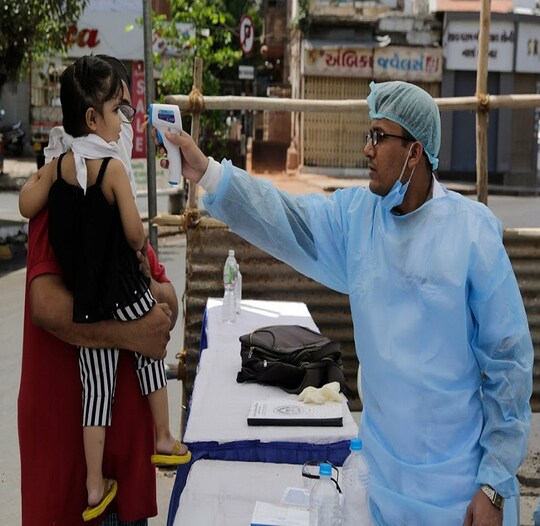 An Indian health worker checks the temperature of a child during lockdown to prevent the spread of new coronavirus in Ahmedabad, India, Wednesday, April 8, 2020. The new coronavirus causes mild or moderate symptoms for most people, but for some, especially older adults and people with existing health problems, it can cause more severe illness or death. (AP Photo/Ajit Solanki)