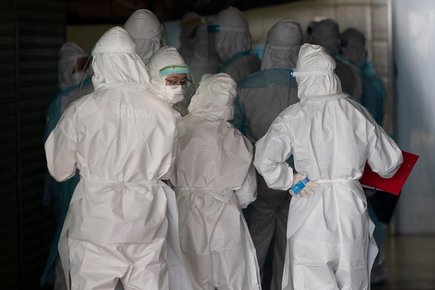 Medical workers in protective suits  entering a building under lockdown in downtown Kuala Lumpur, Malaysia, on Tuesday, April 7, 2020. The Malaysian government issued a restricted movement order to the public to help curb the spread of the new coronavirus. The new coronavirus causes mild or moderate symptoms for most people, but for some, especially older adults and people with existing health problems, it can cause more severe illness or death. (AP Photo/Vincent Thian)