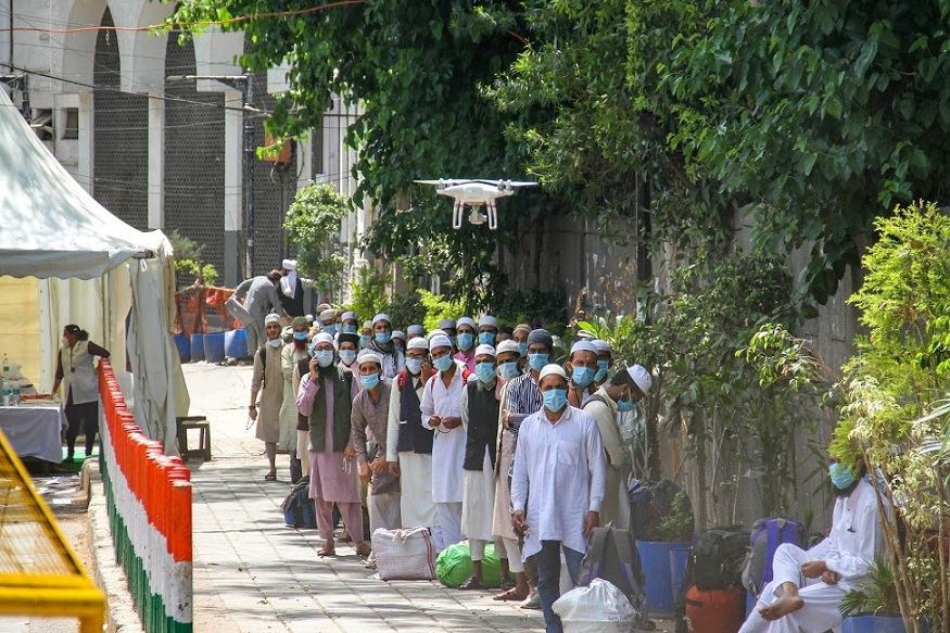 New Delhi: Police use a drone to keep a vigil on the area as people who attended Tabligh-e-Jamaat congregation in Nizamuddin West walk to board a bus for the LNJP Hospital for screening and COVID-19 test, in New Delhi, Tuesday, March 31, 2020. 24 people who took part in the congregation have tested COVID-19 positive. (PTI Photo) (PTI31-03-2020_000089B)