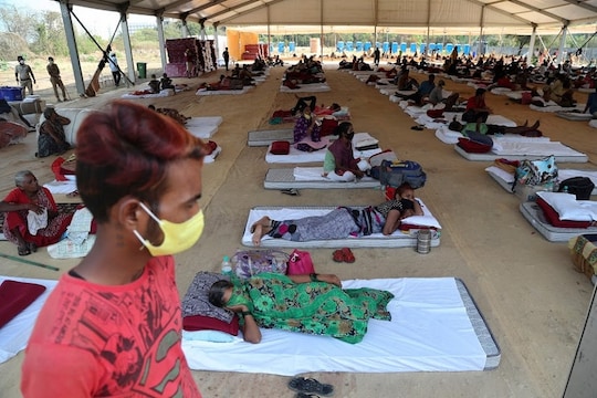 People rest at a shelter set up for migrant workers from other Indian states affected by the coronavirus lockdown in Mumbai, India, Monday, April 6, 2020. The new coronavirus causes mild or moderate symptoms for most people, but for some, especially older adults and people with existing health problems, it can cause more severe illness or death. (AP Photo/Rafiq Maqbool)