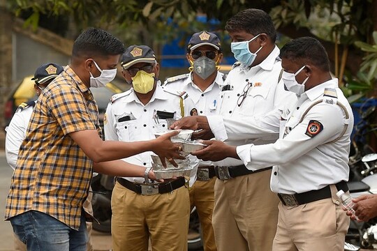 Mumbai: Volunteers of Siddhivinayak Temple Trust distribute food and bottled water to police and traffic police personnel deployed on duty during day-2 of a nationwide lockdown, imposed in the wake of coronavirus pandemic, at Mahim in Mumbai, Thursday, March 26, 2020. (PTI Photo/Kunal Patil)(PTI26-03-2020_000082B)