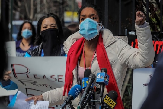 Patricia Armand, an anesthesia nurse at Montefiore Medical Center, speak during an "urgent community speak out" and press conference in front of the hospital, demanding N95s and other critical personal protective equipment to handle the COVID-19 outbreak, Thursday April 2, 2020, in New York. (AP Photo/Bebeto Matthews)