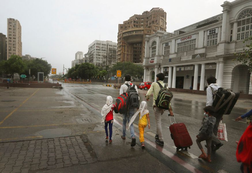 नवी दिल्ली- उत्तर प्रदेशमध्ये पोहोचण्यासाठी बस टर्मिनसकडे जाताना प्रवासी मजूर (फोटो सौजन्य-AP) नवी दिल्ली- उत्तर प्रदेशमध्ये पोहोचण्यासाठी बस टर्मिनसकडे जाताना प्रवासी मजूर (फोटो सौजन्य-AP)