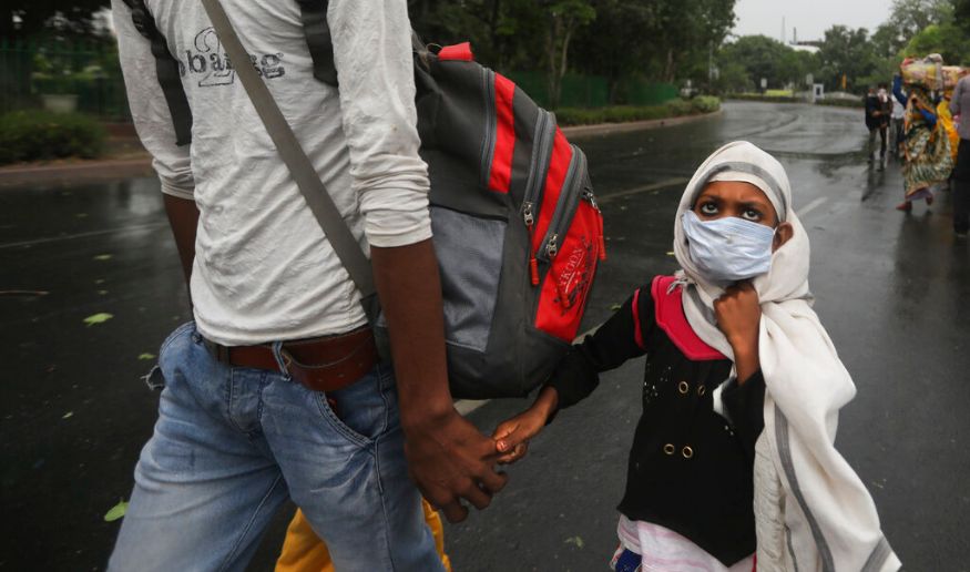 नवी दिल्ली- उत्तर प्रदेशमध्ये पोहोचण्यासाठी बस टर्मिनसकडे जाताना प्रवासी मजूर (फोटो सौजन्य-AP) नवी दिल्ली- उत्तर प्रदेशमध्ये पोहोचण्यासाठी बस टर्मिनसकडे जाताना प्रवासी मजूर (फोटो सौजन्य-AP)