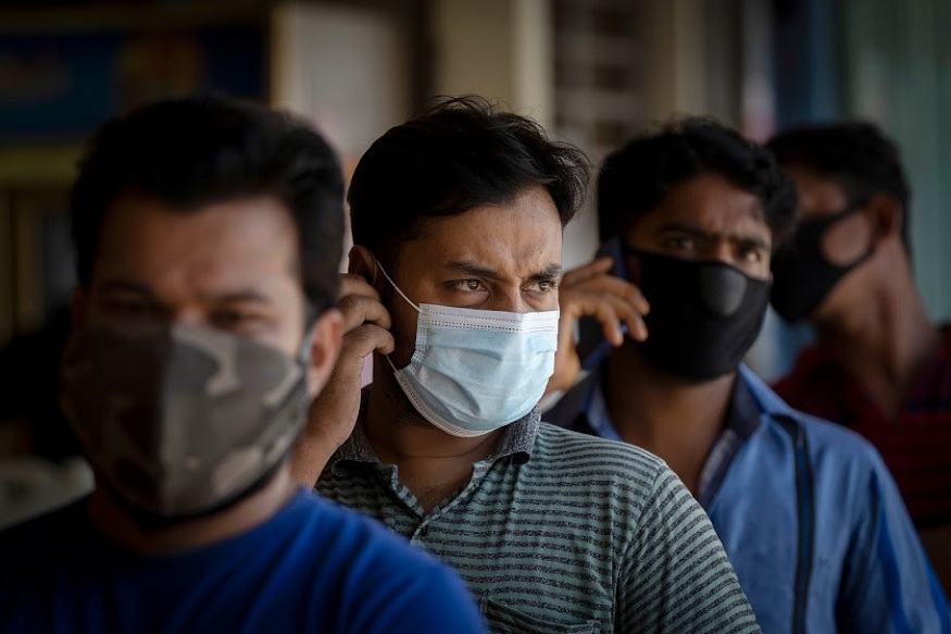 Foreign workers wearing face masks wait for new coronavirus testing at a wet market in Kuala Lumpur, Malaysia Tuesday, May 5, 2020. Malaysia's government says all foreign workers must undergo mandatory virus testing as many business sectors reopen in parts of the country for the first time since a partial virus lockdown began March 18. A senior official says the government has decided to make it compulsory for foreign workers to take virus tests after cases rose over the weekend including a new cluster involving foreign workers at a construction site. (AP Photo/Vincent Thian)